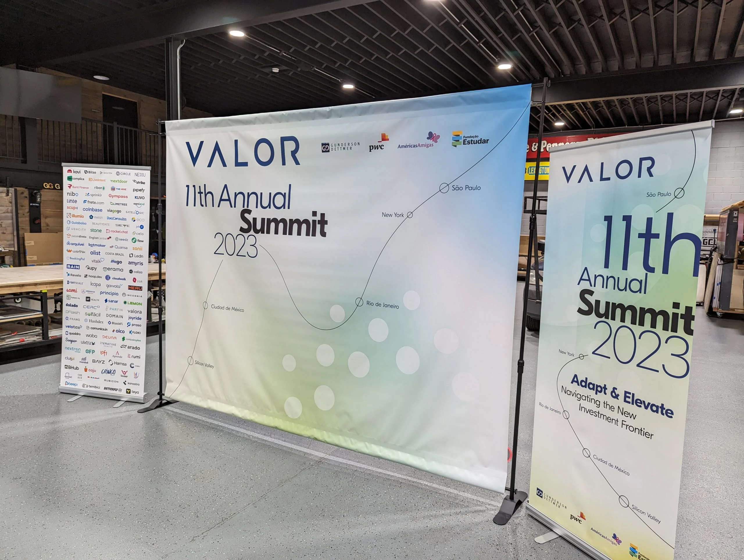 Two printed summit backdrops standing on frames at an event
