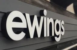 Dimensional letters sized to a storefront fascia in a retail center