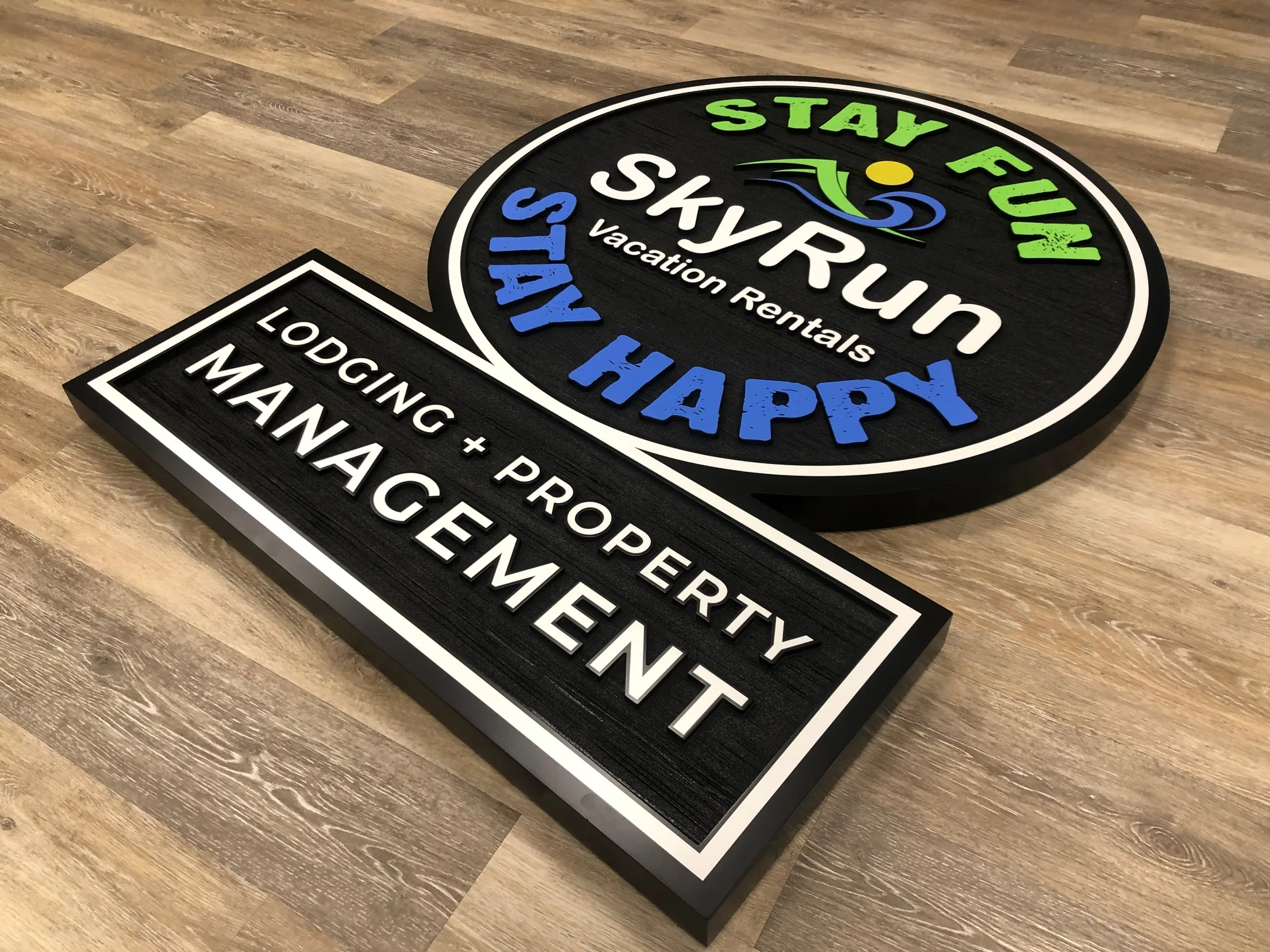 Carved dimensional signs with layered lettering and logo for a property management company