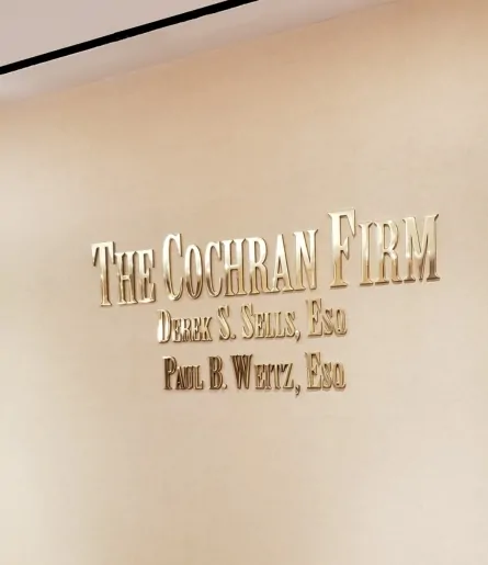 Brushed brass letters for The Cochran Firm mounted on a lobby wall