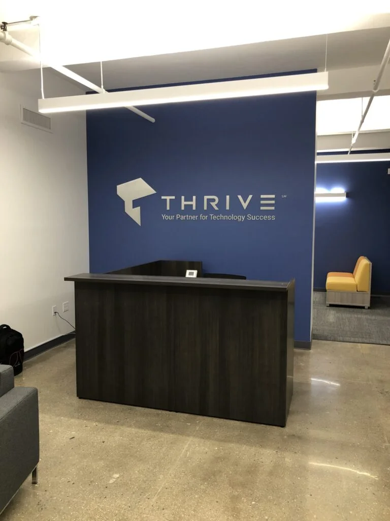 Company logo on a blue feature wall behind a reception desk