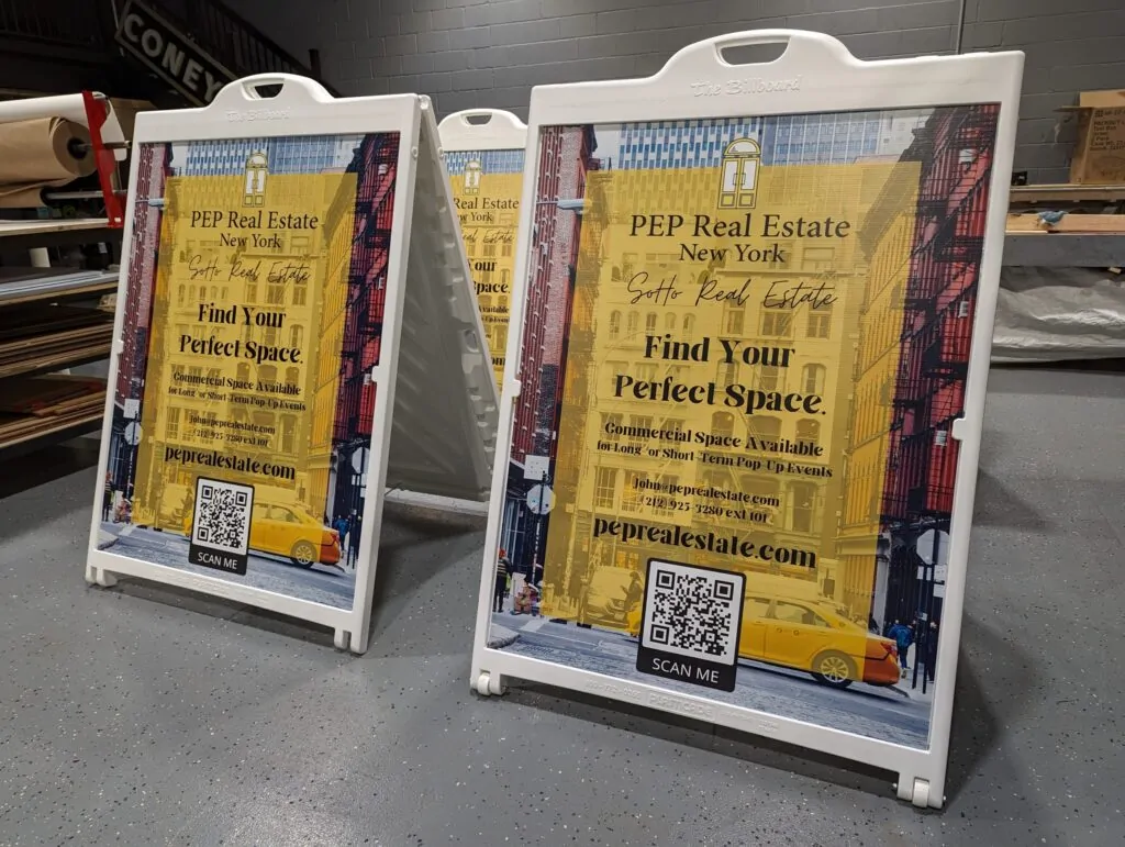 White plastic sandwich boards with real estate posters