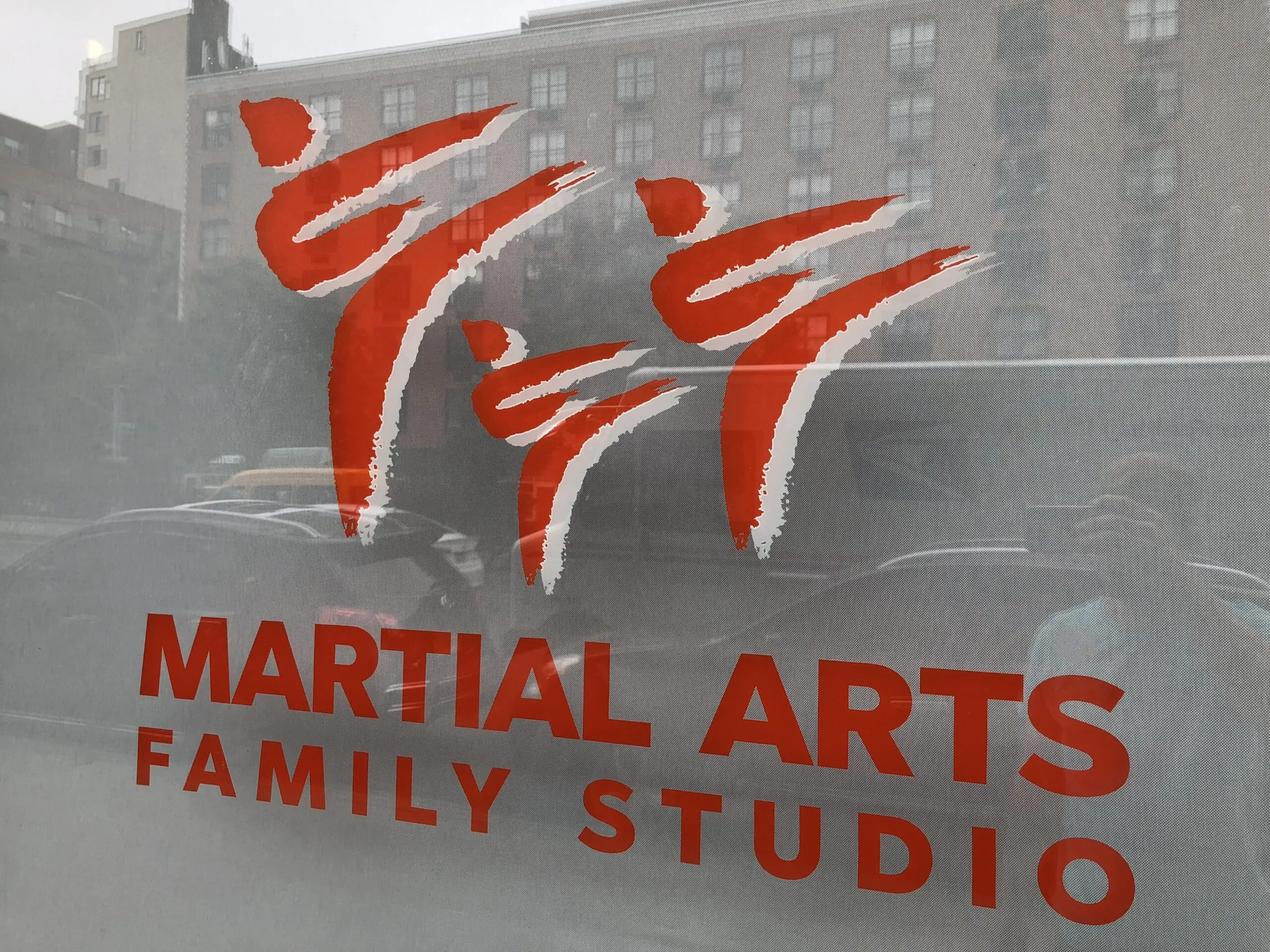 Martial arts studio window with large red lettering visible from across the street