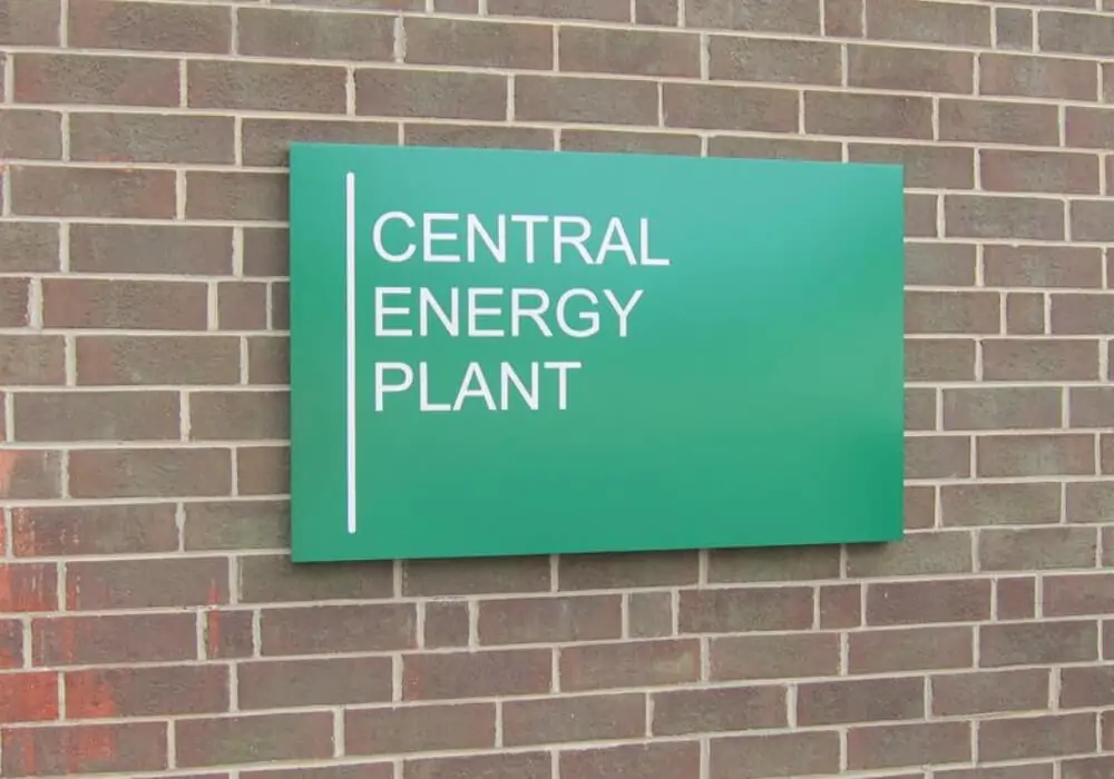 Flat wall mounted panel sign identifying a building, fixed flush to the facade