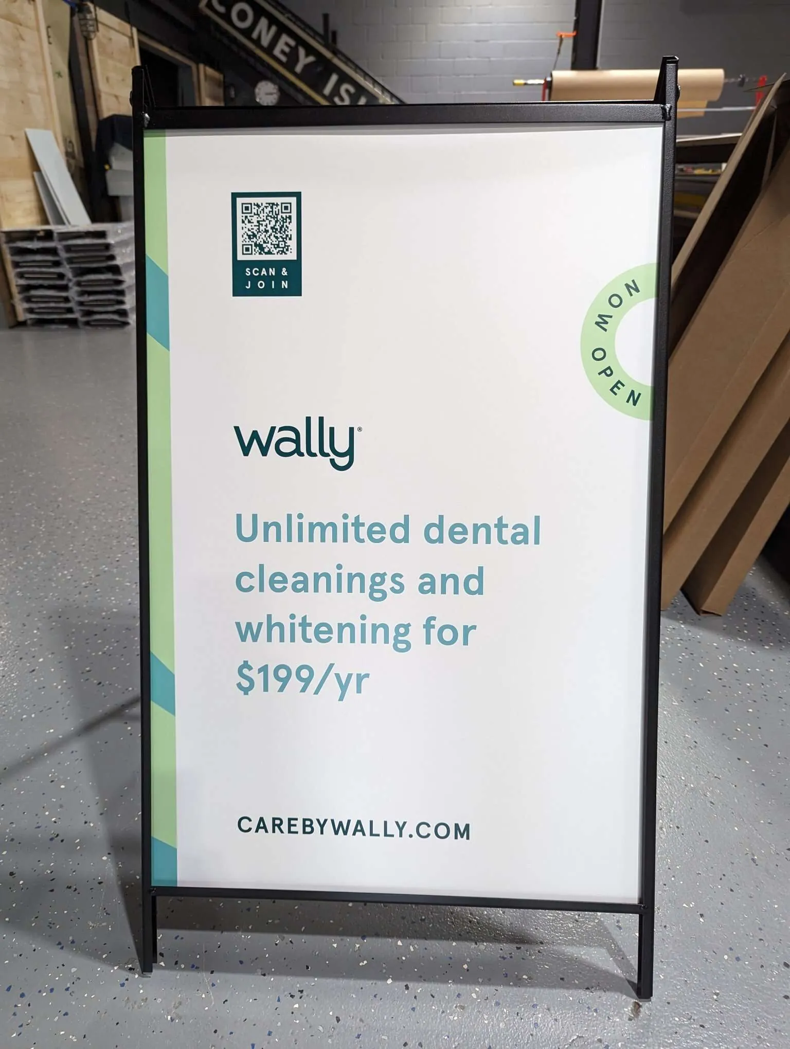 White A frame sidewalk sign for a dental membership plan with a QR code at the top