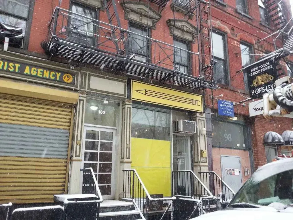 Row of storefronts on a city street photographed straight on from the sidewalk