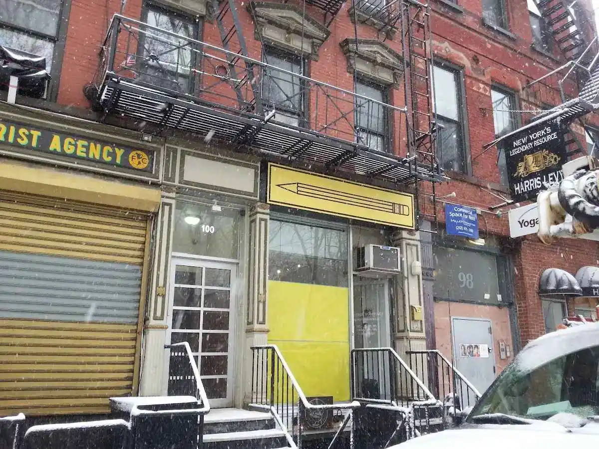 Row of storefronts on a city street photographed straight on from the sidewalk