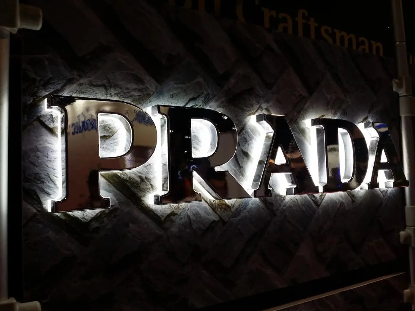 Backlit metal letters on a dark storefront fascia