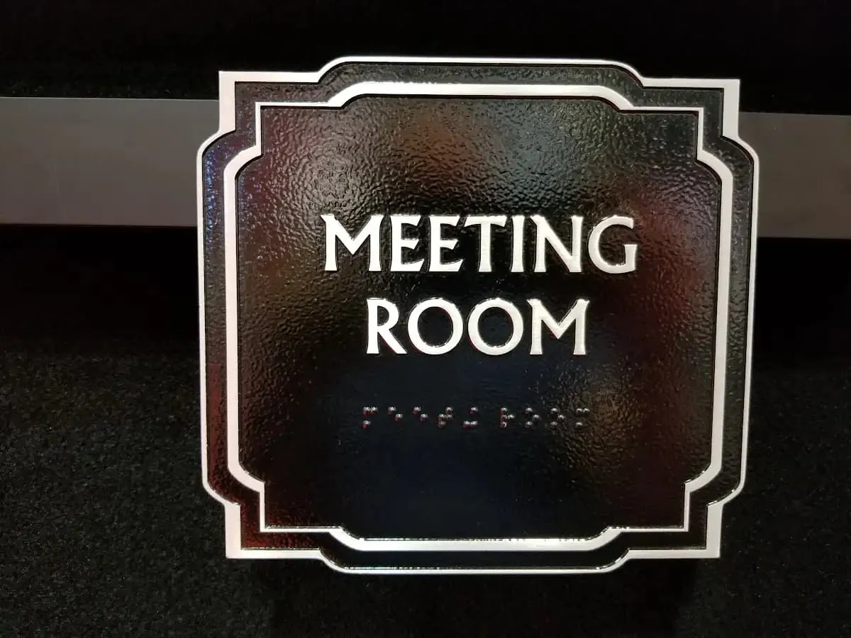 Decorative meeting room sign with raised letters and braille