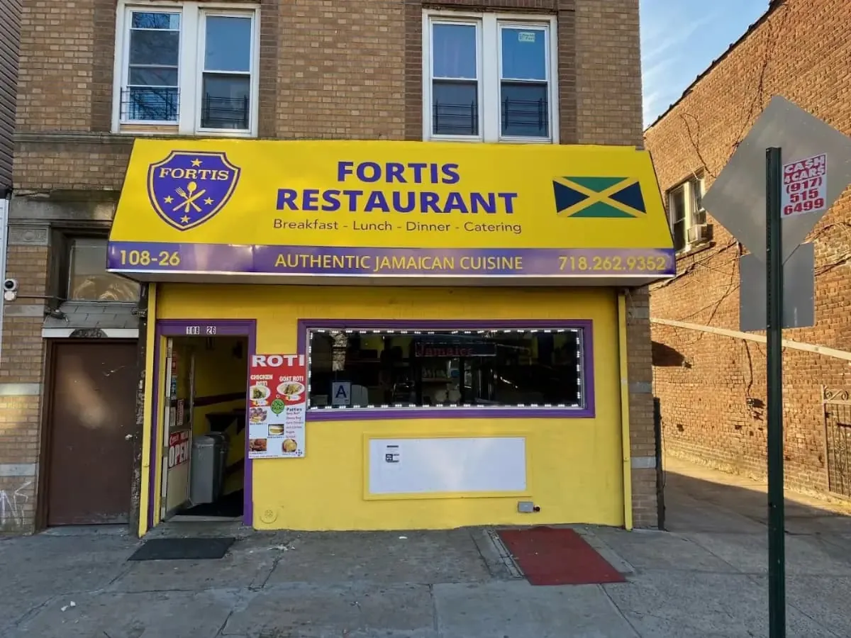 Restaurant storefront with a printed awning and lit window graphics