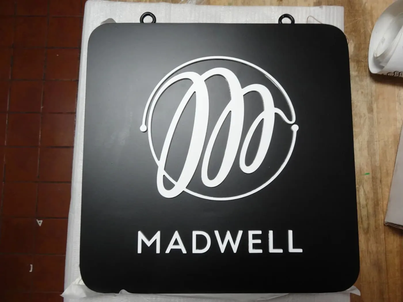 Round projecting blade sign on a bracket above a shop entrance
