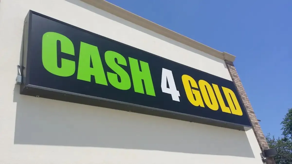 Lit cabinet sign with green and yellow lettering on a black background