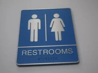 Blue ADA restroom sign with pictograms and braille