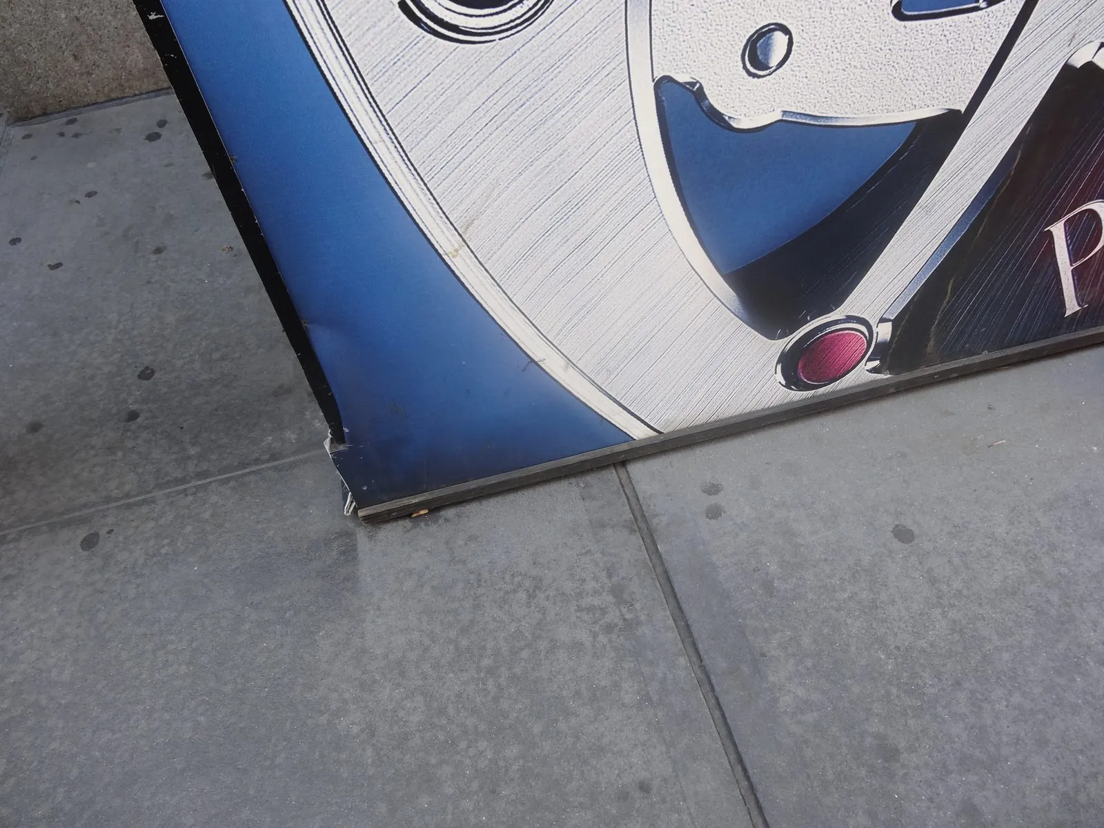 Bottom corner of a printed barricade wall wrap meeting the sidewalk