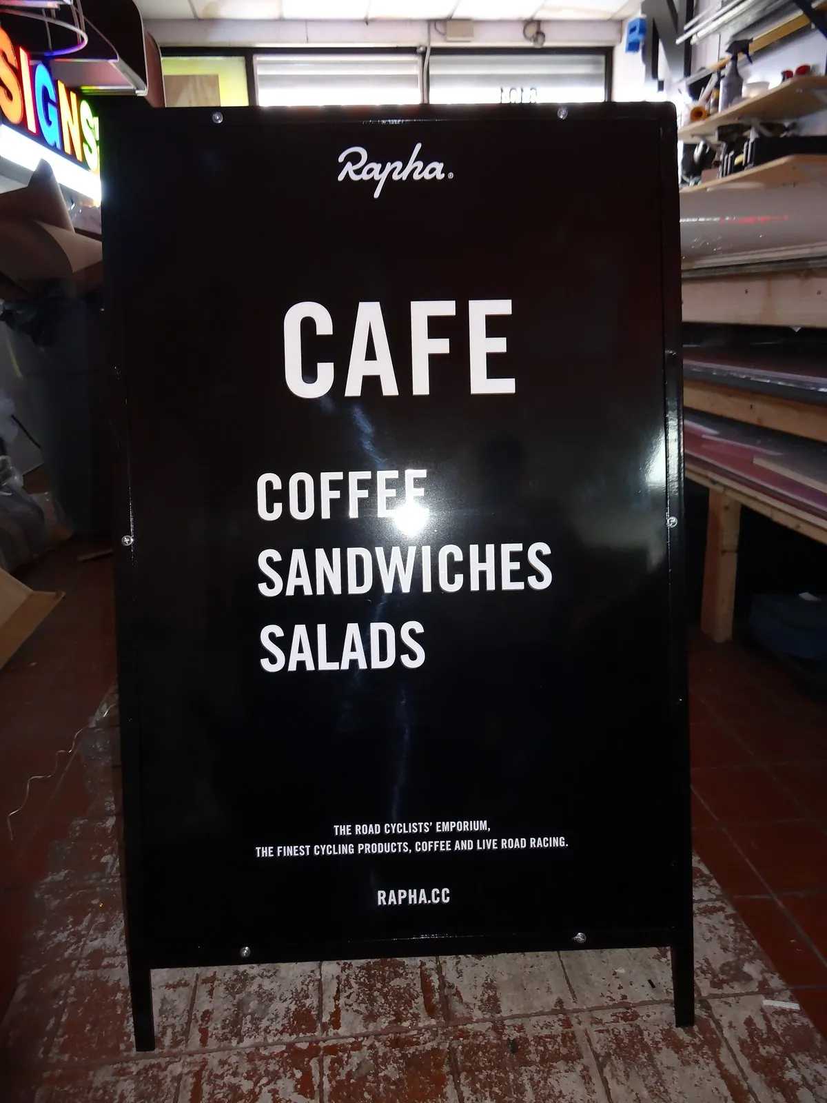 Black metal A frame reading Cafe, coffee, sandwiches and salads