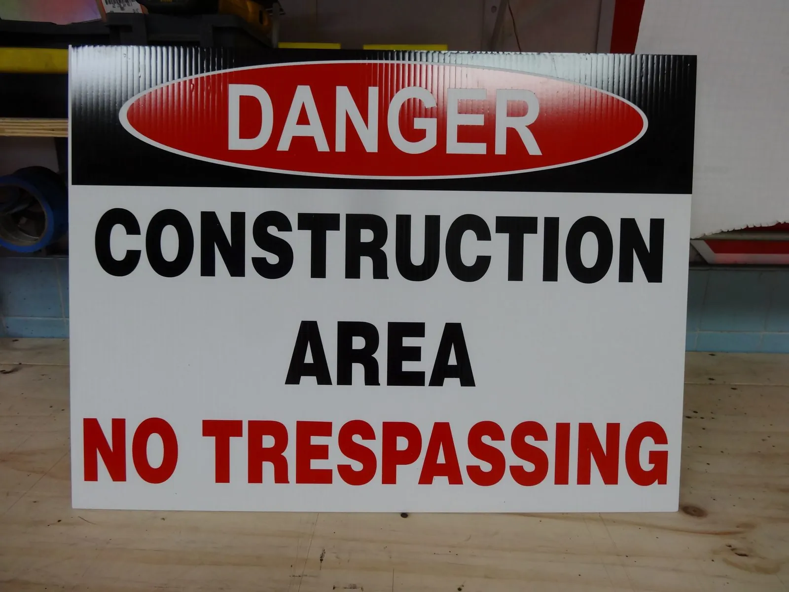 Danger, Construction Area, No Trespassing sign with a red header