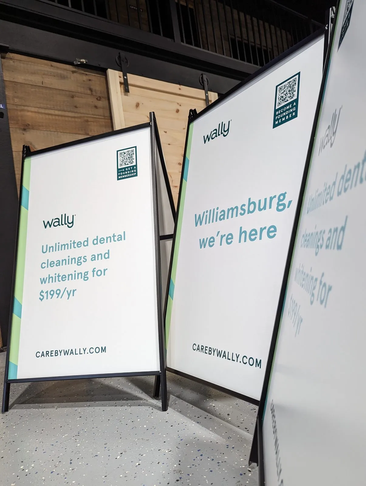 Three A frame signs with dental office ads lined up in the shop