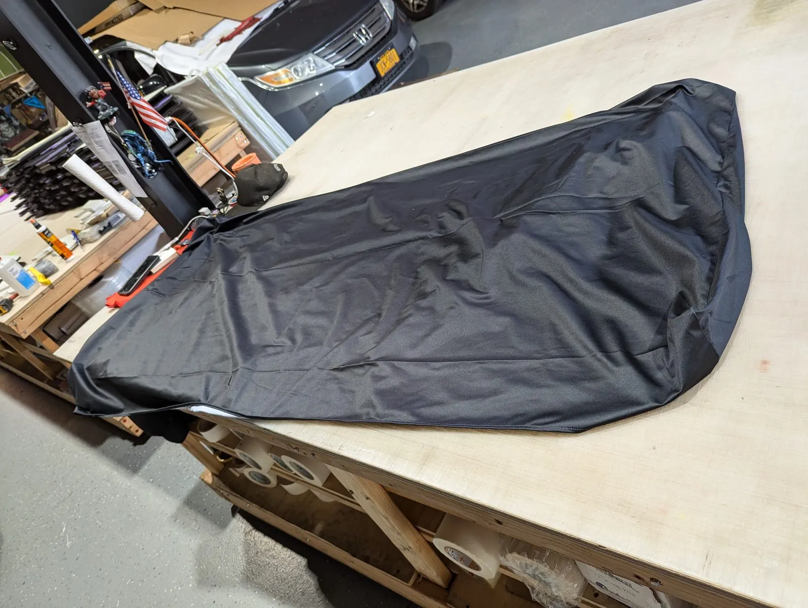 Finished black fabric graphic with a white edge spread out on our shop table