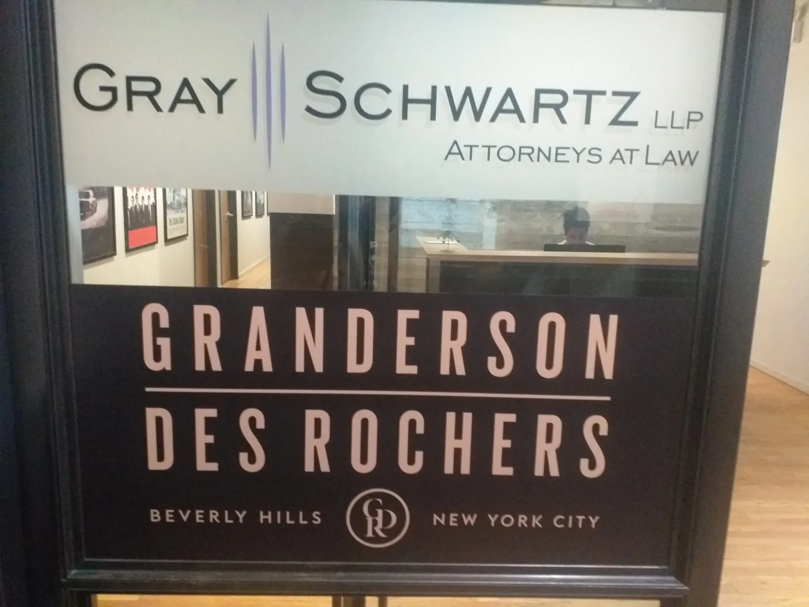 Law office glass door with frosted cut vinyl lettering across the top and a dark lettered panel below
