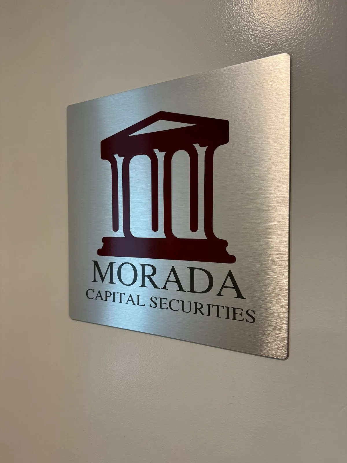 Brushed aluminum wall sign with a maroon cut vinyl column logo and company name