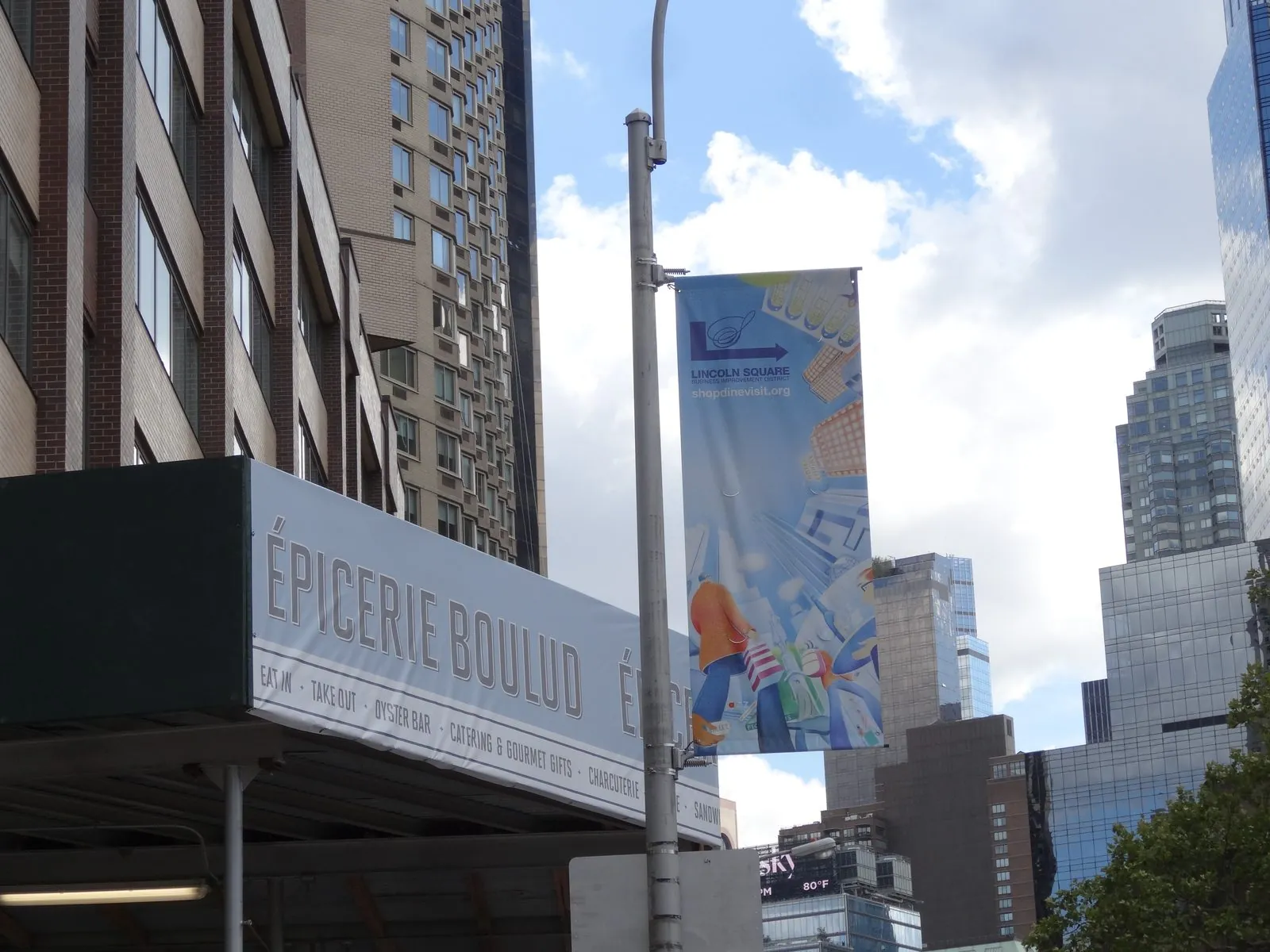 Printed banner wrapped along the front of a sidewalk shed on a city street