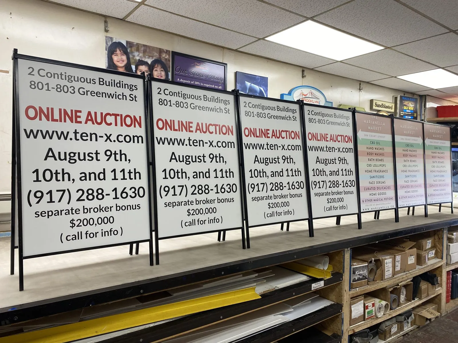 Printed auction sign faces lined up in metal frames in the shop