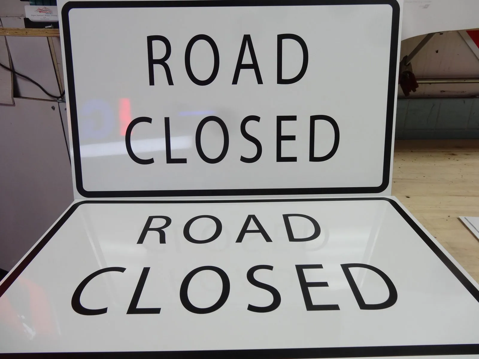 Two Road Closed signs in black letters on white with a black border
